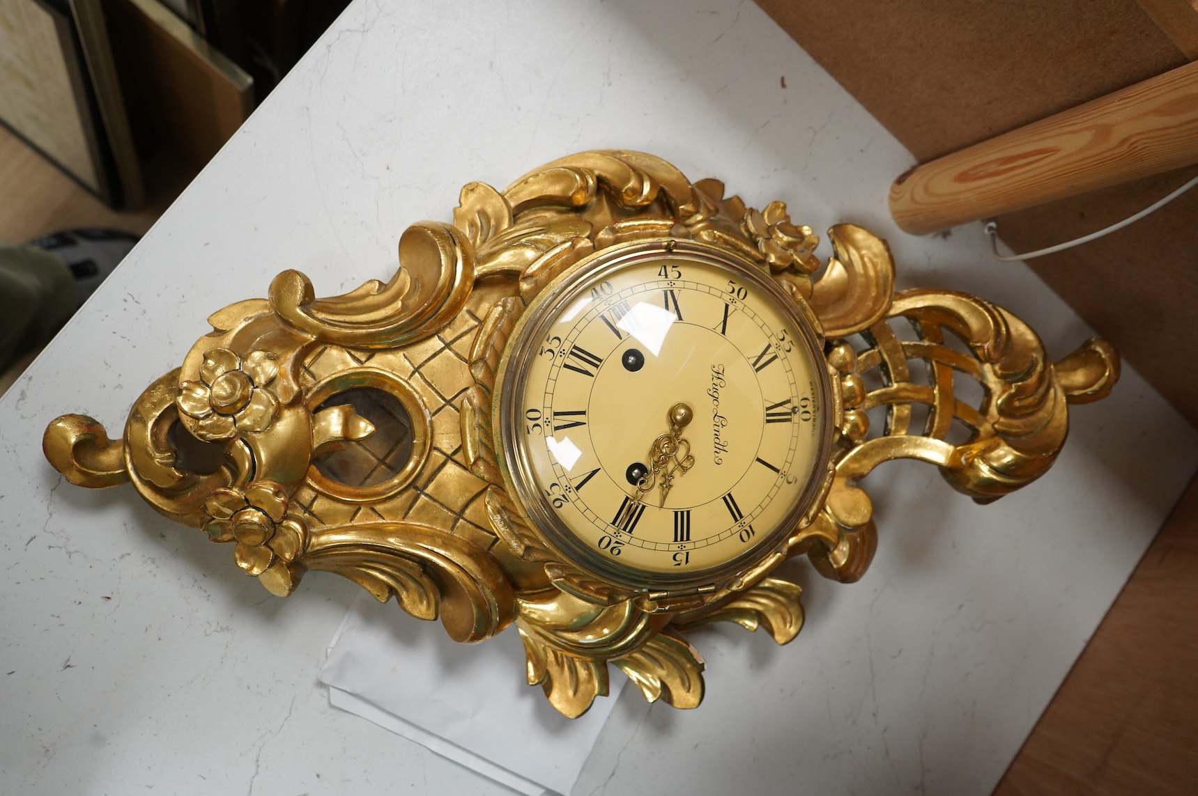 A Swedish giltwood rococo style cartel clock, convex enamel dial signed Hugo Lindh, Westerstrand, with key and pendulum, 56cm high